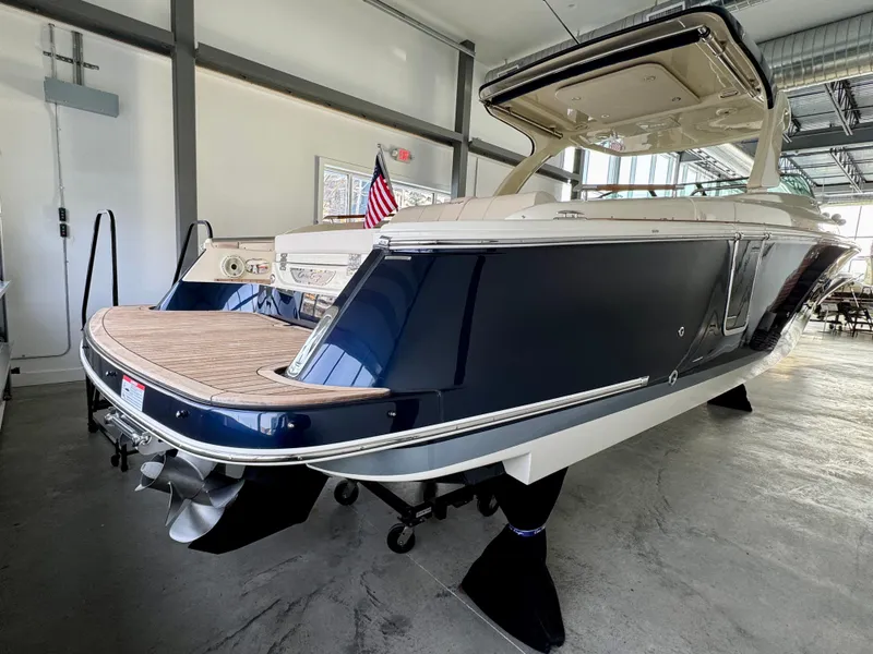 Slide: The Image of 2024 Chris-Craft Launch 35 GT boat in showroom, rear view with American flag. - 43