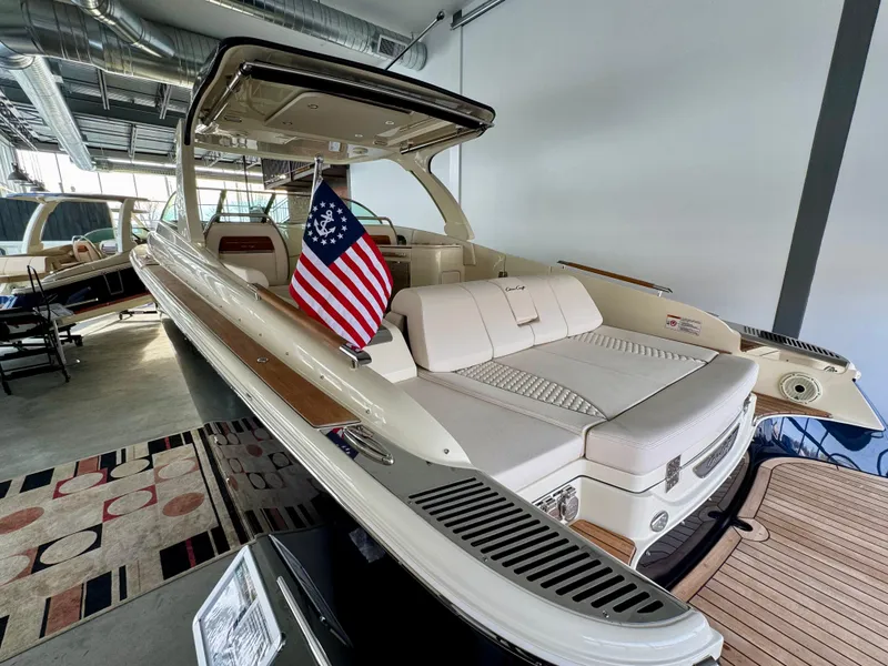 Slide: The Image of 2024 Chris-Craft Launch 35 GT boat with American flag, displayed indoors. - 45