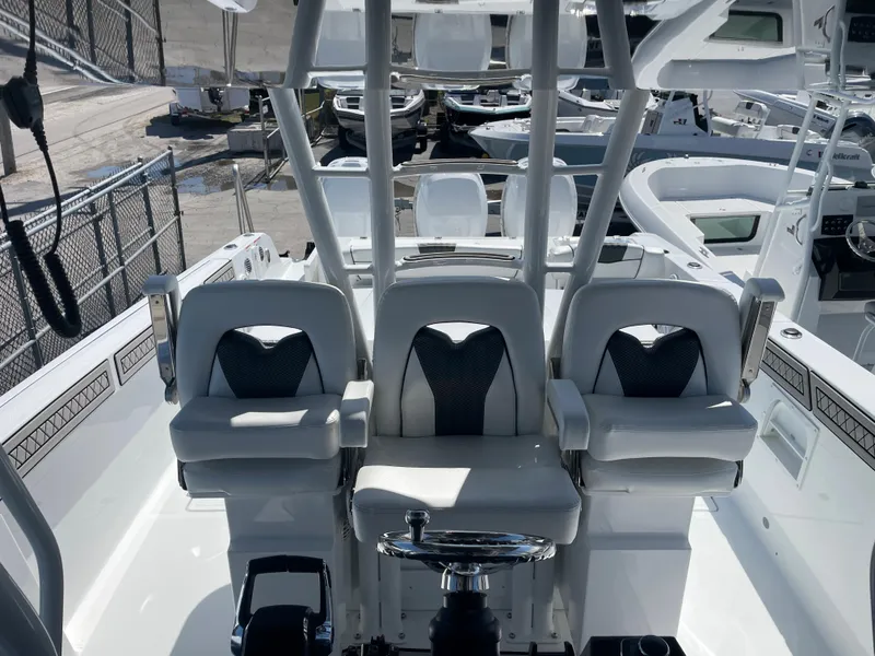 Slide: The Image of 2023 Wellcraft 352 Fisherman boat interior with three cushioned seats and steering wheel. - 16