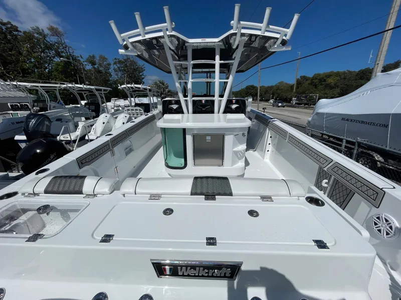 Slide: The Image of 2023 Wellcraft 352 Fisherman boat, spacious deck, modern design, white exterior, clear blue sky. - 3