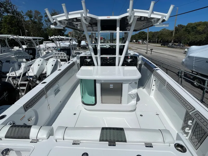 Slide: The Image of 2023 Wellcraft 352 Fisherman boat interior with seating and storage, docked under clear blue sky. - 4