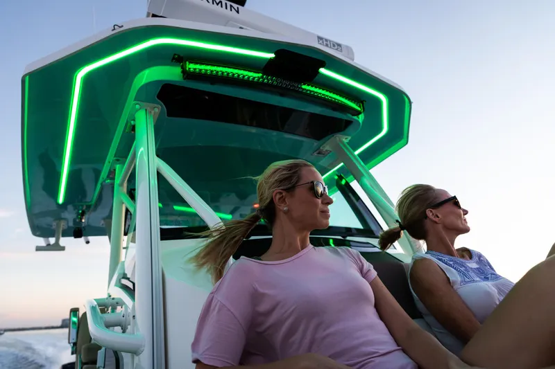 Slide: The Image of 2023 Wellcraft 352 Fisherman boat with neon lights, two women relaxing onboard. - 47