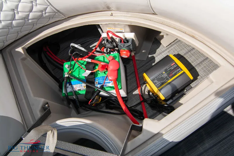 Slide: The Image of Battery compartment of 2022 Manitou 23 Encore RF SHP boat with wiring and charger. - 32