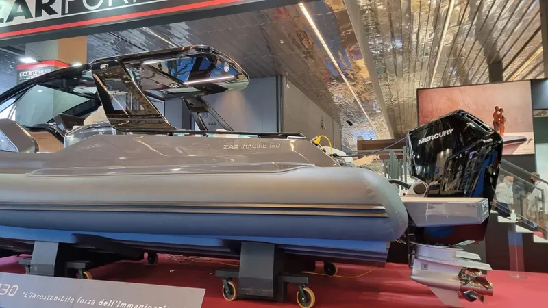 Slide: The Image of 2024 Zar Formenti Imagine 130 boat displayed indoors with Mercury engine. - 3