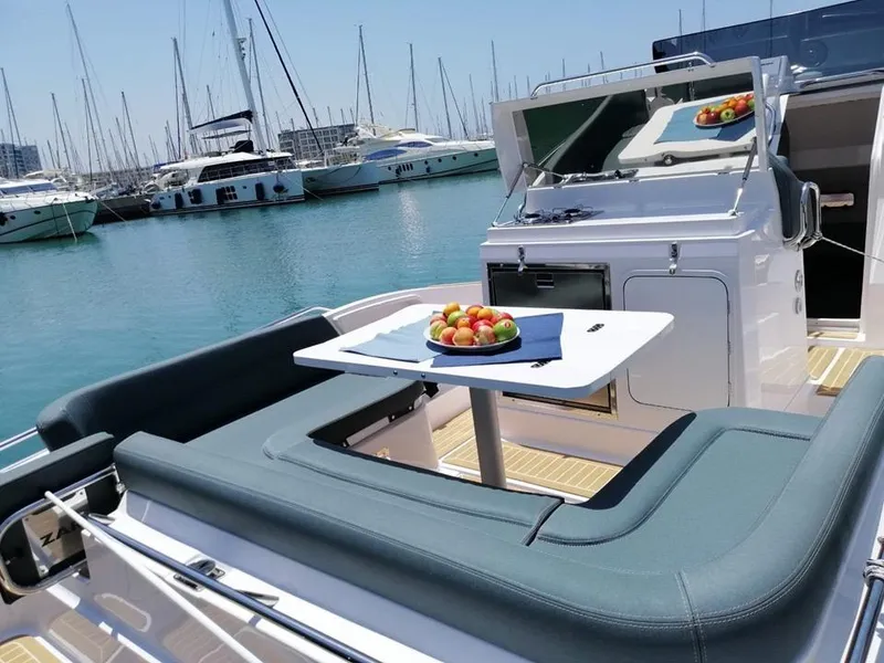 Slide: The Image of 2024 Zar Formenti 95SL boat with seating area and table, docked in a marina. - 4