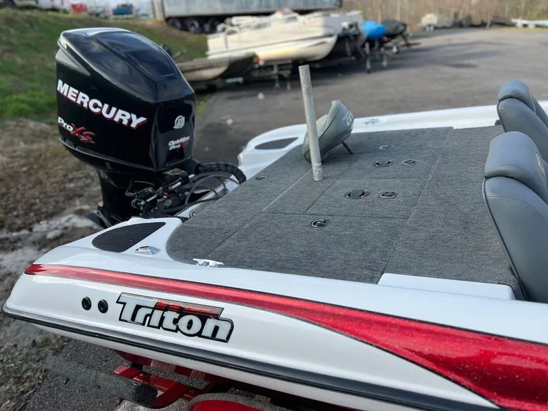 Slide: The Image of 1999 Triton TR20 boat with Mercury Pro XS engine, docked outdoors. - 11