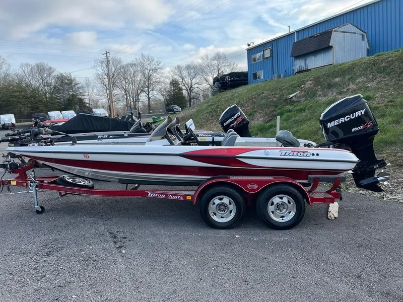 Slide: The Image of 1999 Triton TR20 boat on trailer with Mercury outboard motor, parked outdoors. - 5