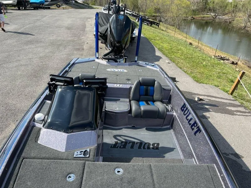 Slide: The Image of 2022 Bullet 21XRS bass boat on a trailer near a river. - 4