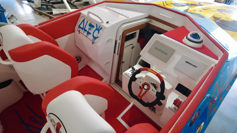 Slide: The Image of 2023 Cigarette 35 Cafe Racer boat interior with red and white seating, Garmin navigation. - 4