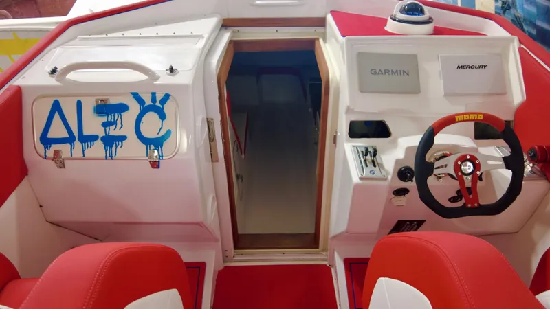 Slide: The Image of 2023 Cigarette 35 Cafe Racer boat interior with red seats and steering wheel. - 5