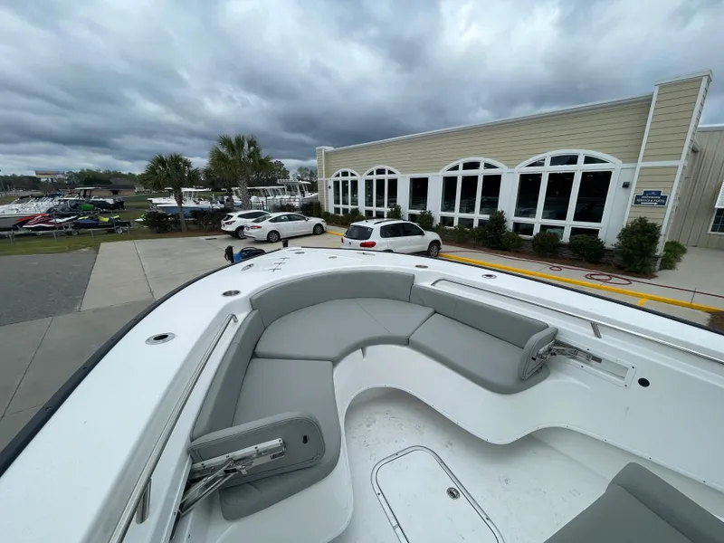 Slide: The Image of 2026 Cape Horn 24XS boat with sleek seating, parked near a modern building. - 20