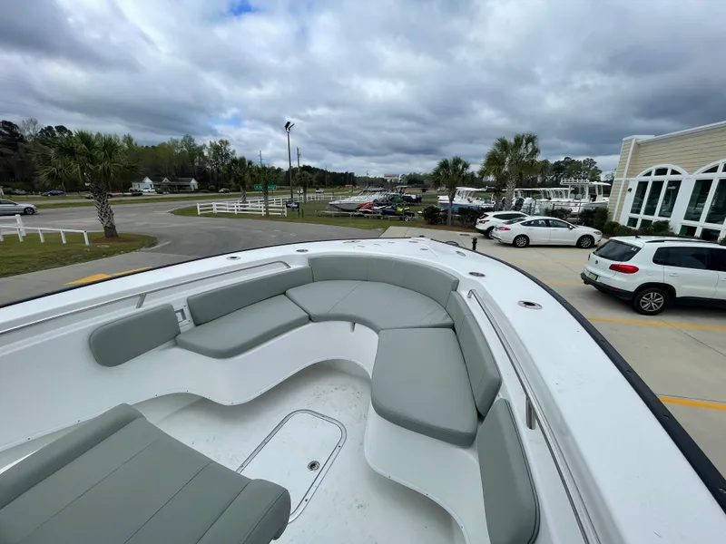 Slide: The Image of 2026 Cape Horn 24XS boat with spacious seating, parked near a marina under cloudy skies. - 21