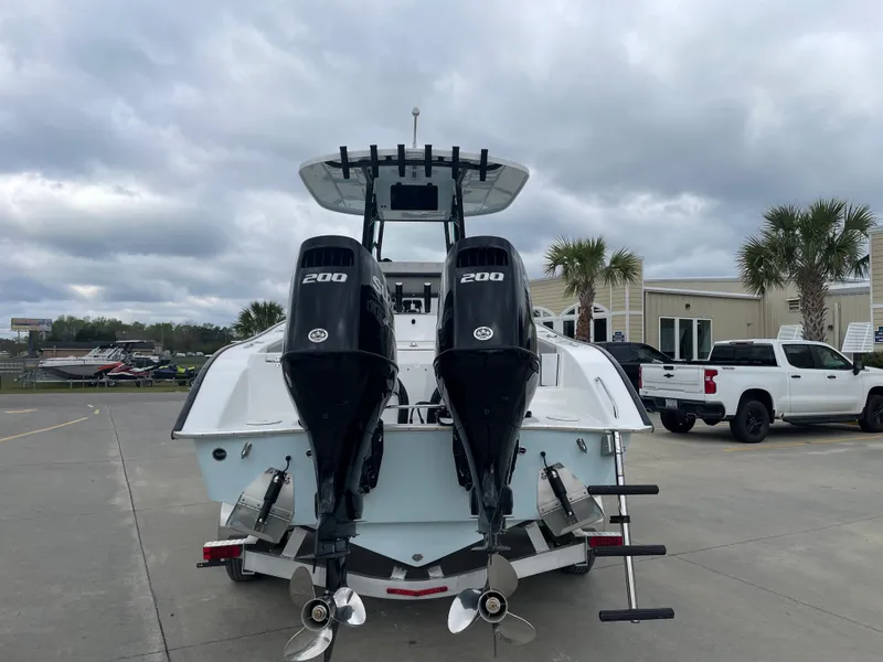 Slide: The Image of 2026 Cape Horn 24XS boat with dual 200 horsepower engines, parked outdoors. - 4