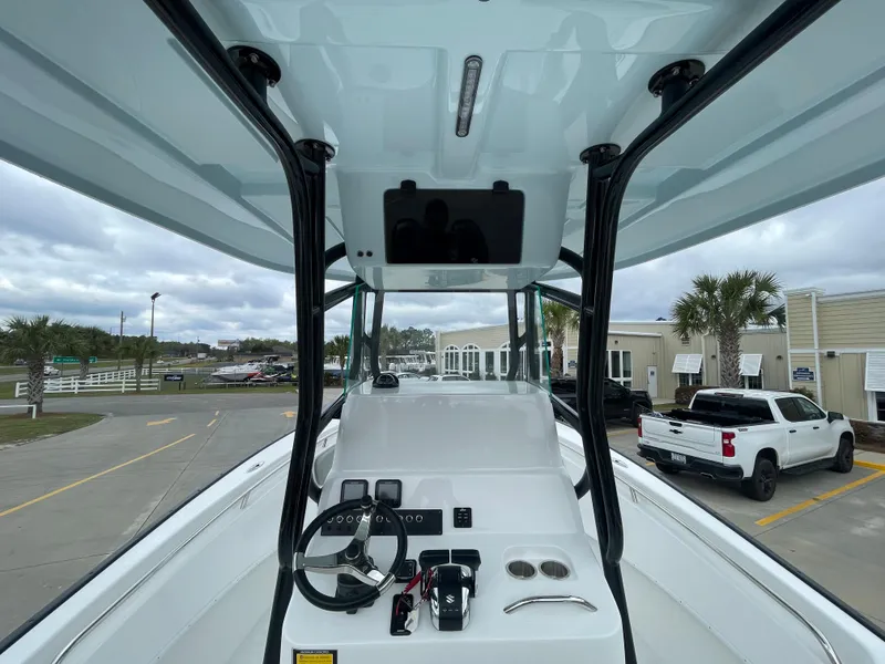 Slide: The Image of 2026 Cape Horn 24XS boat console with steering wheel and controls, parked outdoors. - 7