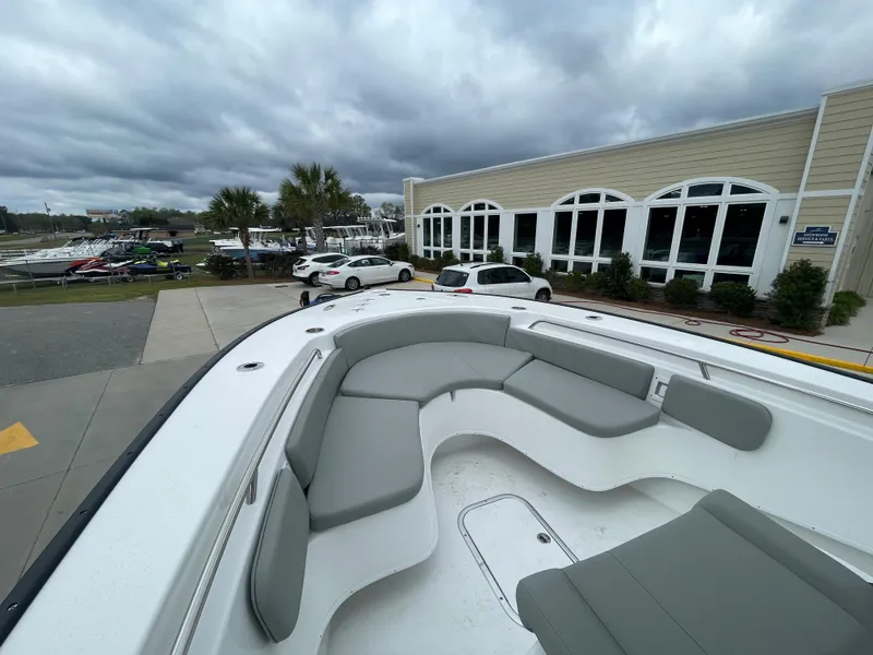 Slide: The Image of 2026 Cape Horn 24XS boat with spacious seating, parked near a building under cloudy skies. - 19