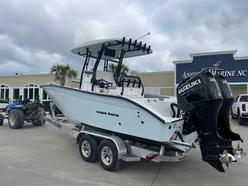 Slide: The Image of 2026 Cape Horn 24XS boat on trailer with Suzuki outboard motor, parked at dealership. - 3