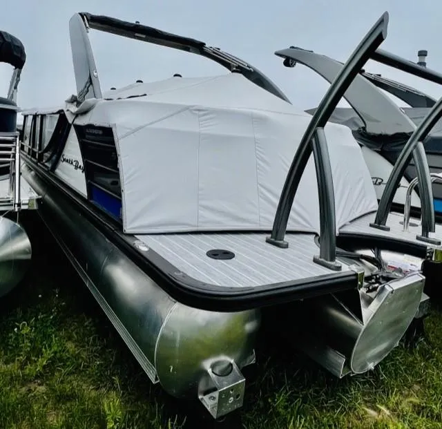 Slide: The Image of 2023 South Bay 525ARCH3.0 pontoon boat with cover, docked on grass. - 1