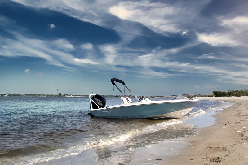 Slide: The Image of 2024 Boston Whaler 160 Super Sport boat on a sandy beach with a scenic sky. - 7