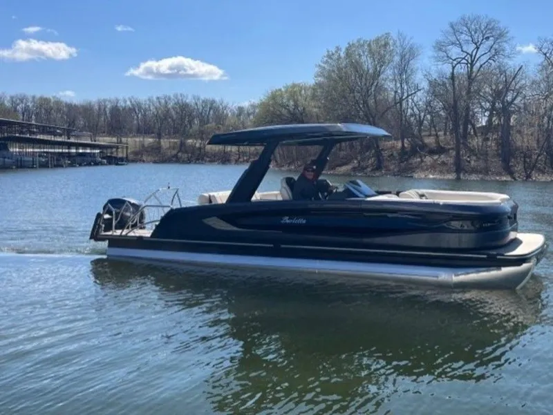 Slide: The Image of 2023 Barletta Reserve V26UC pontoon boat on a calm lake. - 0