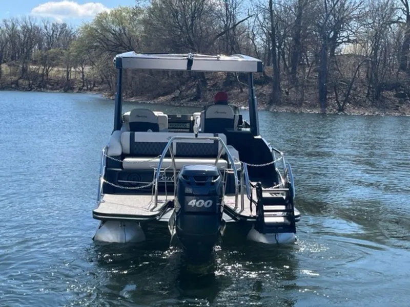Slide: The Image of 2023 Barletta Reserve V26UC pontoon boat cruising on a serene lake. - 8