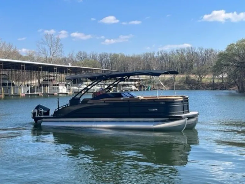 Slide: The Image of 2023 Harris Solstice DC 250 SLDH pontoon boat on a calm lake. - 10
