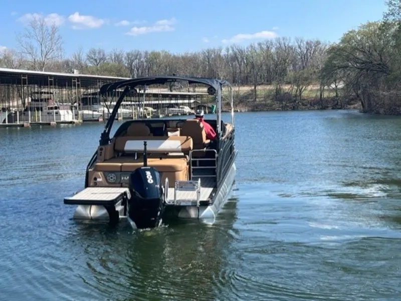 Slide: The Image of 2023 Harris Solstice DC 250 SLDH pontoon boat on a calm lake. - 15