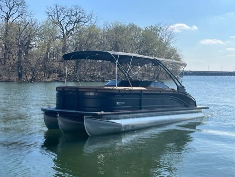 Slide: The Image of 2023 Harris Solstice DC 250 SLDH pontoon boat on a calm lake. - 16