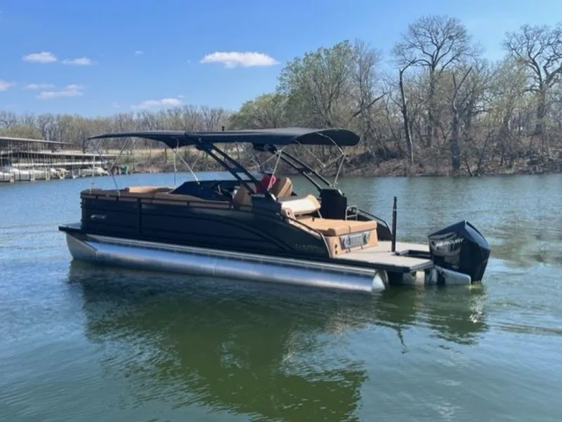 Slide: The Image of 2023 Harris Solstice DC 250 SLDH pontoon boat on a calm lake. - 17
