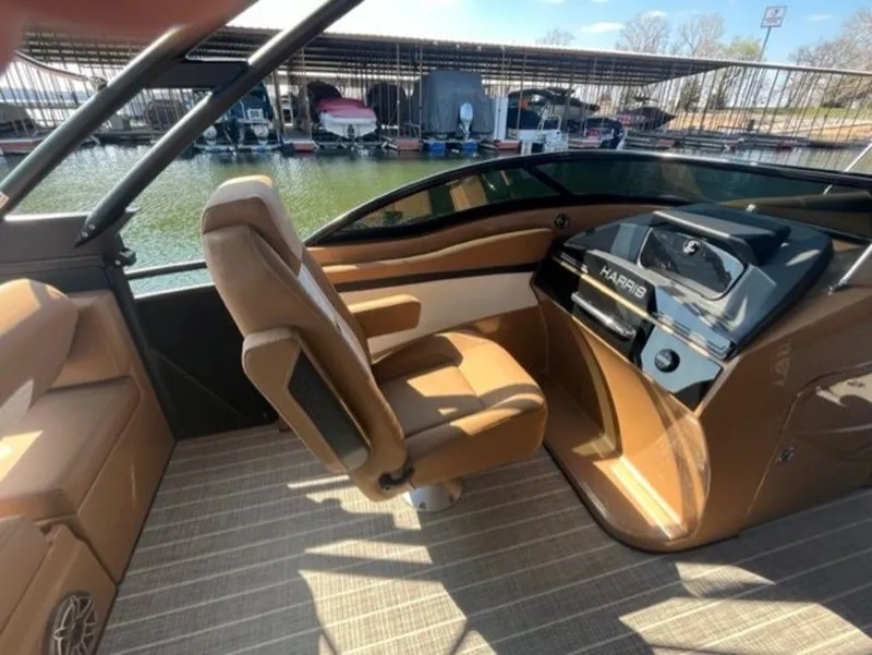 Slide: The Image of 2023 Harris Solstice DC 250 SLDH boat interior with brown seating and modern dashboard. - 4