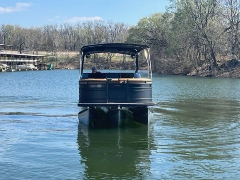 Slide: The Image of 2023 Harris Solstice DC 250 SLDH pontoon boat cruising on a serene lake. - 9