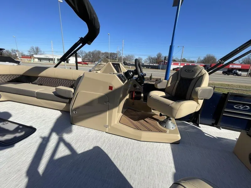 Slide: The Image of 2023 Harris Sunliner 250 boat interior with beige seating and steering console. - 10