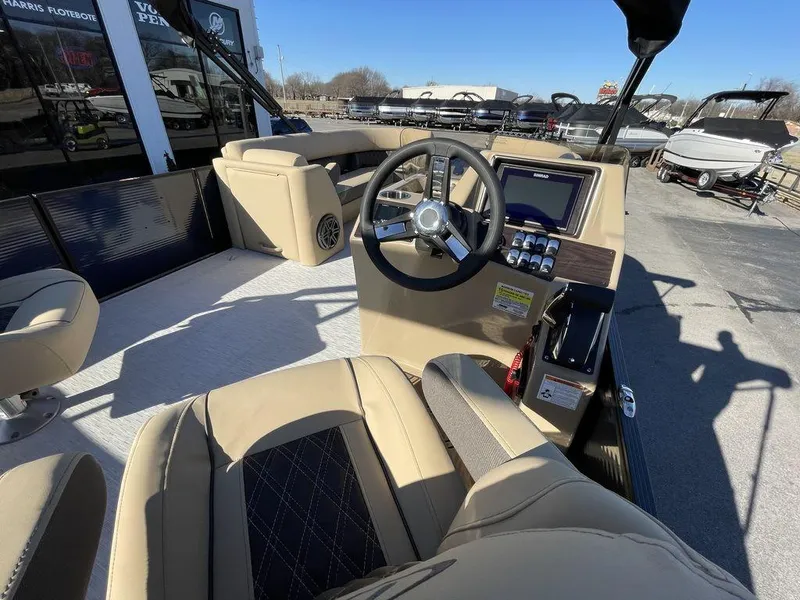 Slide: The Image of 2023 Harris Sunliner 250 boat interior with steering wheel and seating. - 15