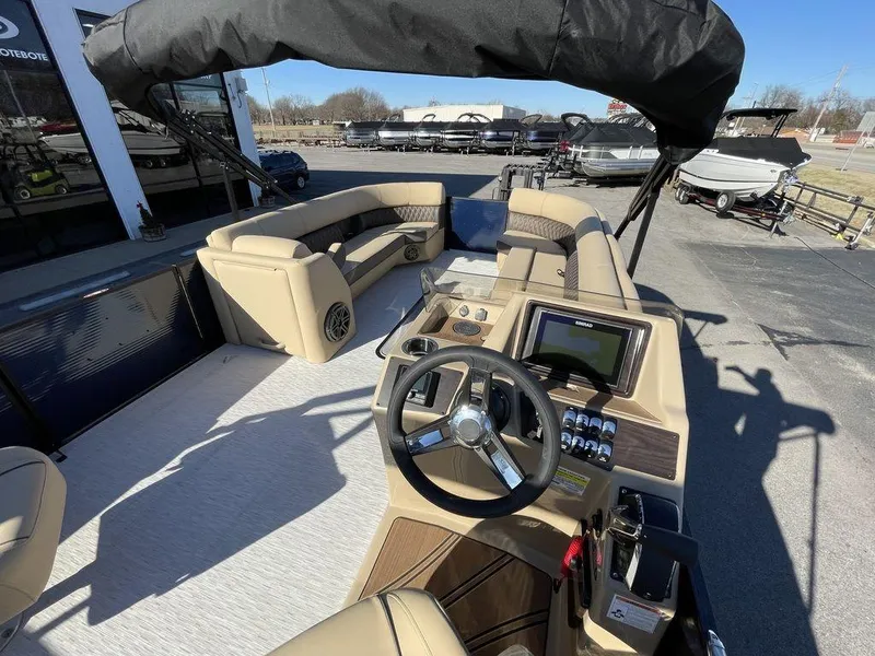 Slide: The Image of 2023 Harris Sunliner 250 boat interior with steering wheel and seating area. - 16