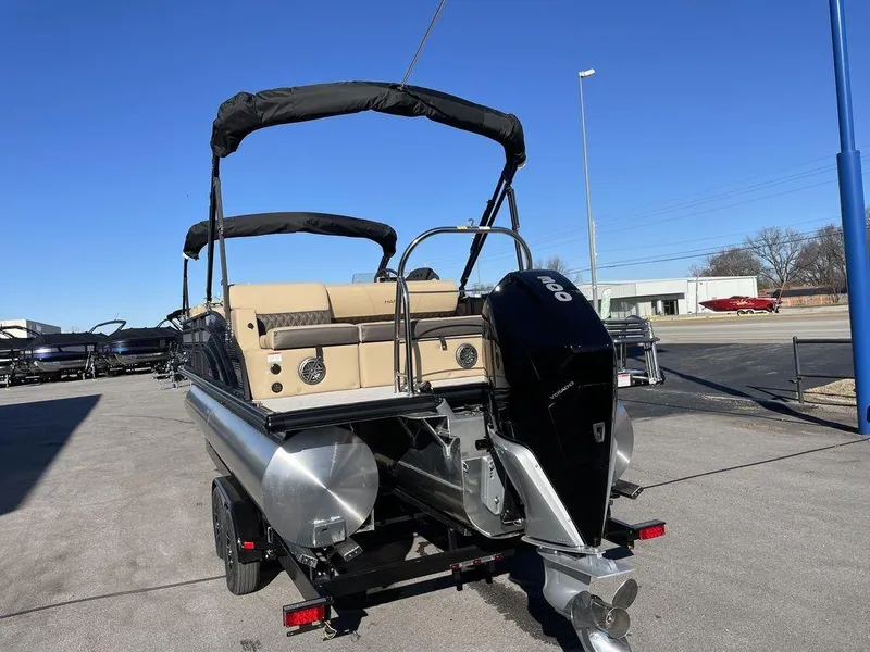 Slide: The Image of 2023 Harris Sunliner 250 pontoon boat with outboard motor, parked on a trailer. - 17