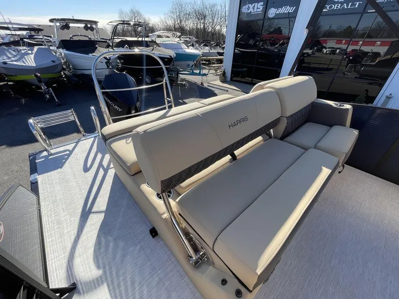 Slide: The Image of 2023 Harris Sunliner 250 boat with beige seating, displayed outdoors. - 18