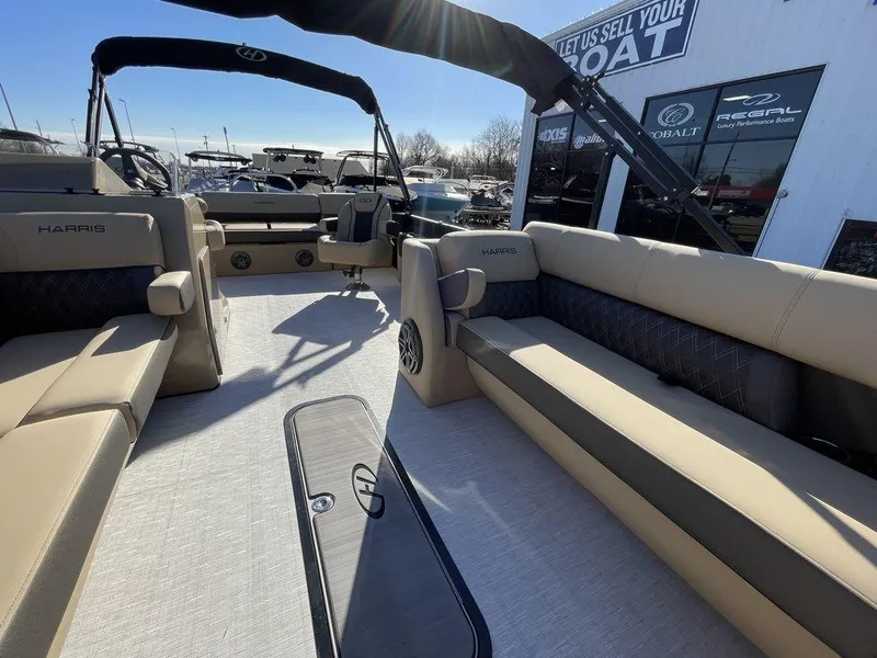 Slide: The Image of 2023 Harris Sunliner 250 pontoon boat interior with beige seating and black accents. - 2