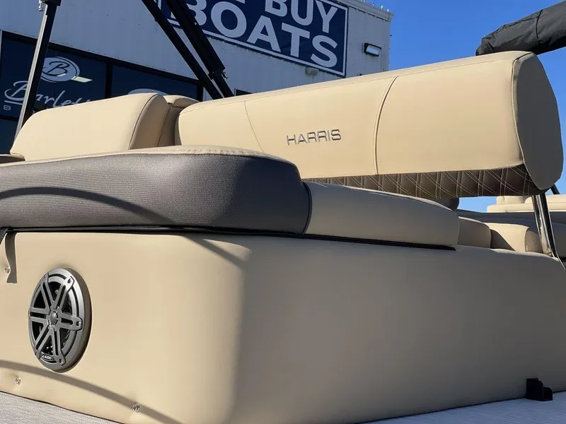 Slide: The Image of 2023 Harris Sunliner 250 boat seating with speaker, displayed at a dealership. - 20