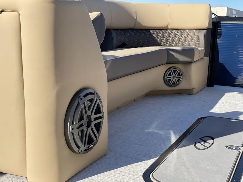 Slide: The Image of 2023 Harris Sunliner 250 boat interior with beige seating and built-in speakers. - 27