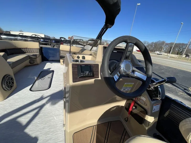 Slide: The Image of 2023 Harris Sunliner 250 boat interior with steering wheel and seating area. - 29