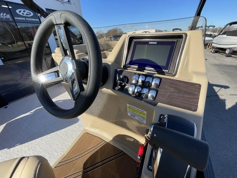 Slide: The Image of 2023 Harris Sunliner 250 boat dashboard with steering wheel and control panel. - 3