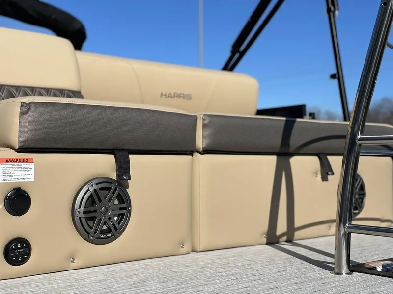 Slide: The Image of 2023 Harris Sunliner 250 boat interior with beige seating and speaker system. - 31
