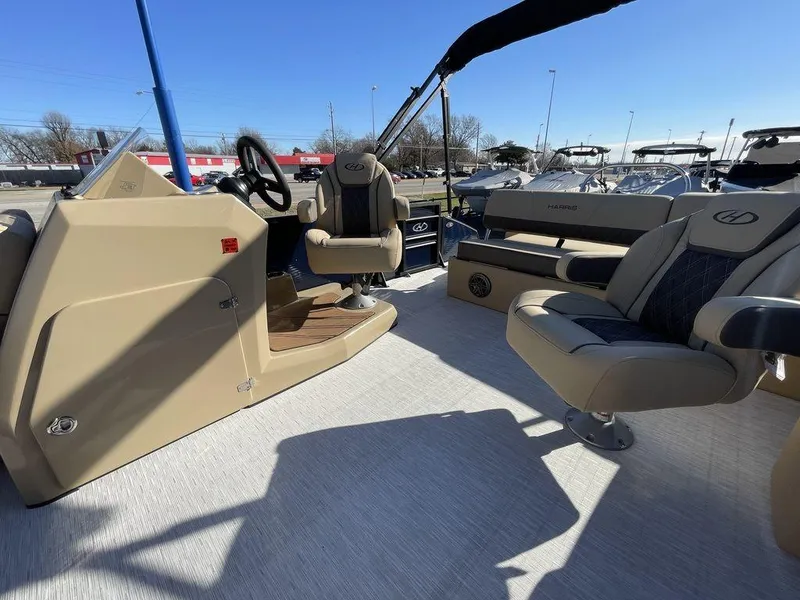 Slide: The Image of 2023 Harris Sunliner 250 boat interior with beige seating and steering console. - 35