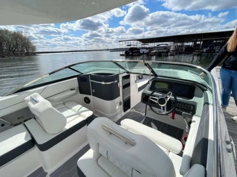Slide: The Image of 2023 Regal LS6 boat interior with sleek design, docked by a scenic lake. - 4