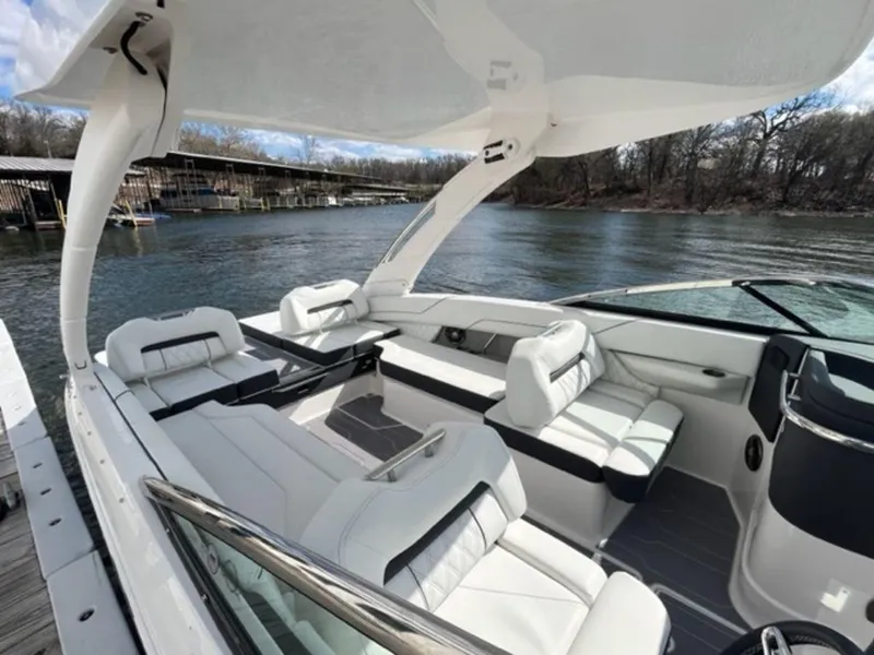 Slide: The Image of 2023 Regal LS6 boat with luxurious white seating on a serene lake. - 9