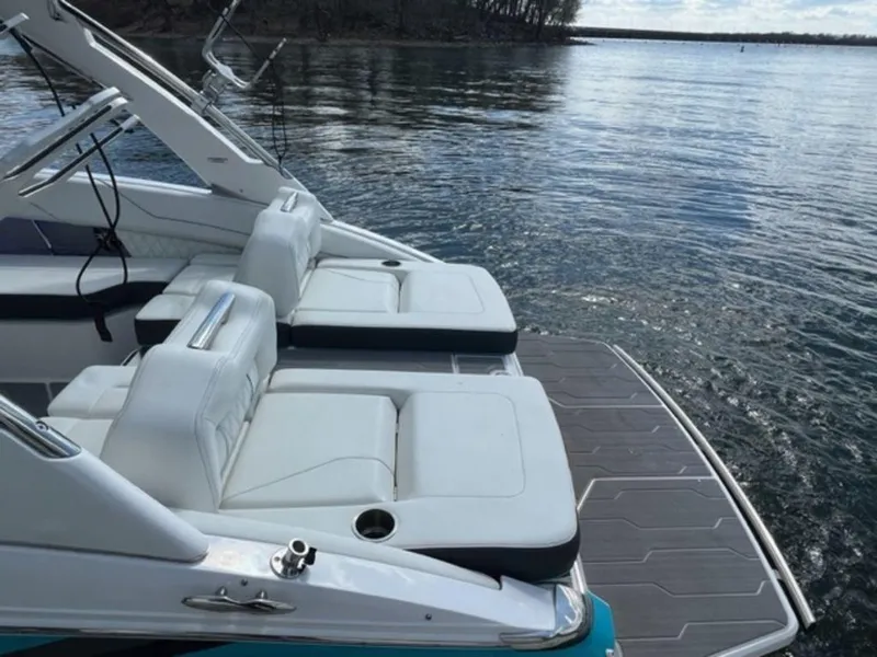 Slide: The Image of 2023 Regal LS6 Surf boat with white seating on a calm lake. - 11