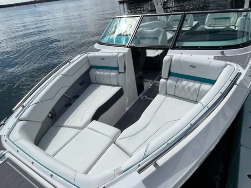 Slide: The Image of 2023 Regal LS6 Surf boat with luxurious white seating on calm water. - 12
