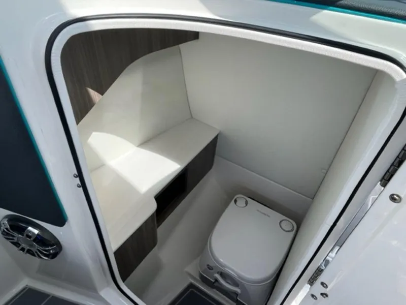 Slide: The Image of 2023 Regal LS6 Surf boat interior bathroom with compact toilet and storage. - 14