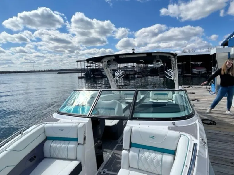 Slide: The Image of 2023 Regal LS6 Surf boat docked on a sunny day with a smiling person nearby. - 17