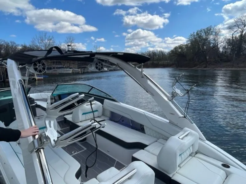 Slide: The Image of 2023 Regal LS6 Surf boat on a calm lake under a blue sky. - 20
