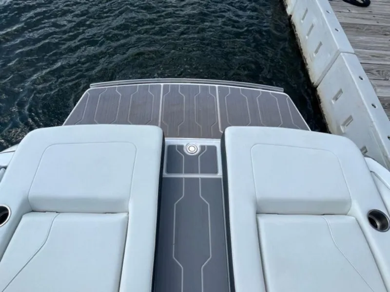 Slide: The Image of 2023 Regal LS6 Surf boat deck by the water, featuring sleek design and comfortable seating. - 5